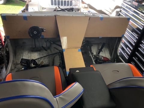 1992 Jeep Wrangler - The interior of a vehicle build is shown with custom-made cardboard panels being fitted to the dashboard area. A drill and other tools are…