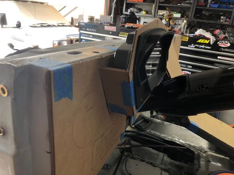 1992 Jeep Wrangler - A cardboard template is taped to a vehicle's dashboard structure, with a black steering column extending from the right. The background sho…