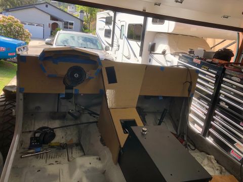1992 Jeep Wrangler - The interior of a Jeep Wrangler is shown with a cardboard dashboard mockup in place. Tools and a black storage box are visible on the floor.