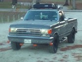 Gray Ford F-150 pickup truck with roof rack and cargo box