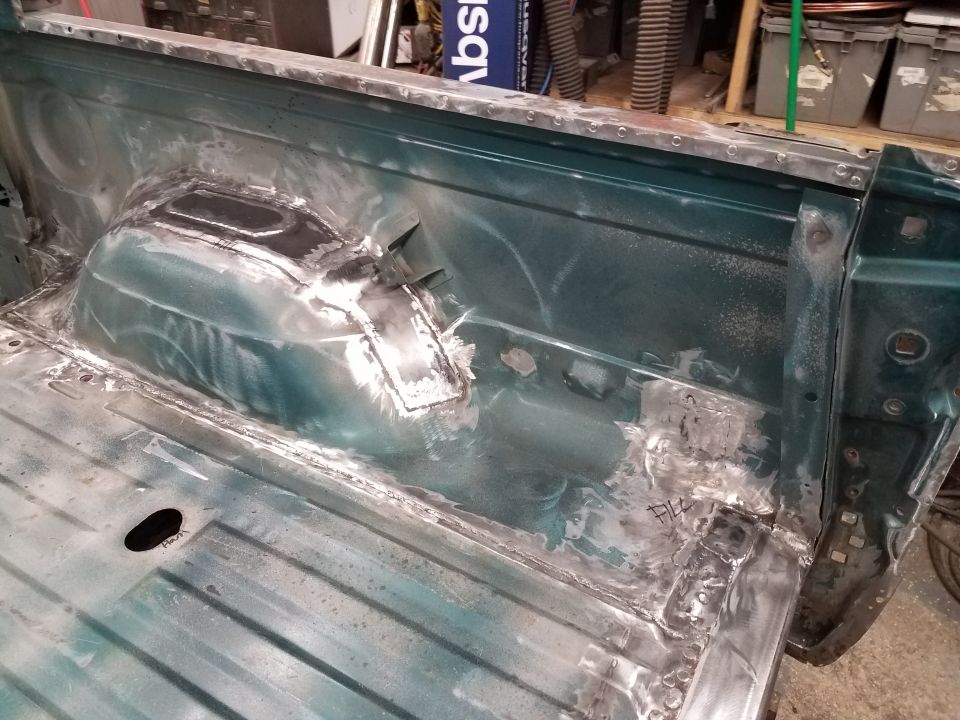 Interior bed of a green 1994 Ford Bronco with visible welding and metal repair.