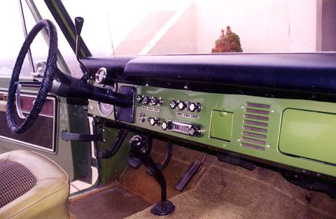 1973 Ford Bronco - The interior of a 1973 Ford Bronco features a green dashboard with chrome accents, a period-correct radio, and a distinctive steering wheel.