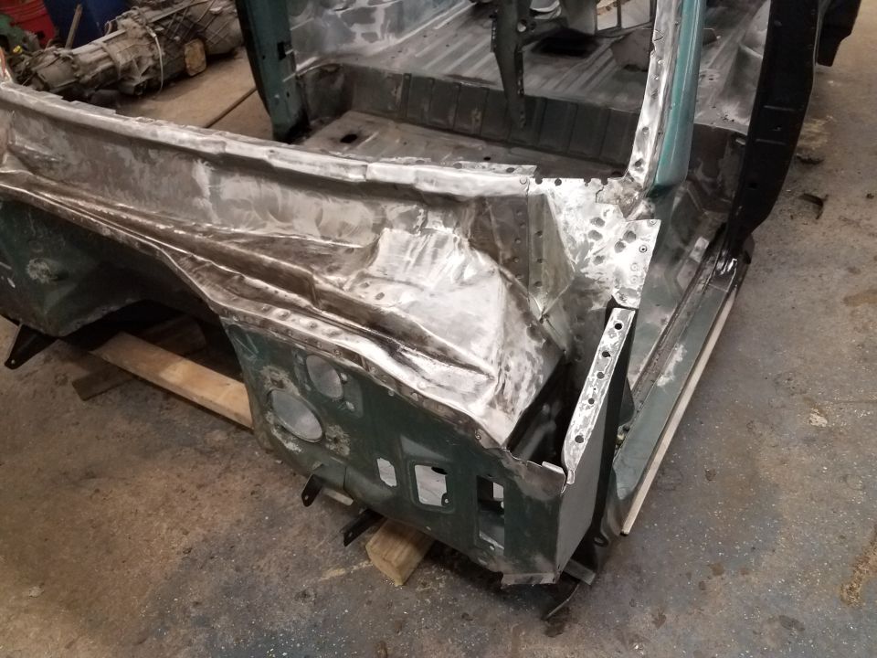 Rear section of a classic SUV body undergoing metal repair and restoration.