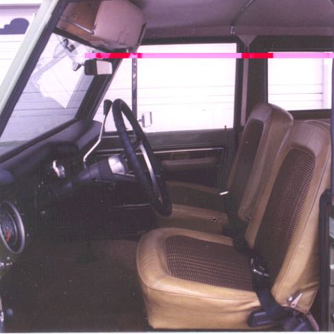 1973 Ford Bronco - The interior of a classic Ford Bronco features tan seats with a patterned insert and a dark dashboard.