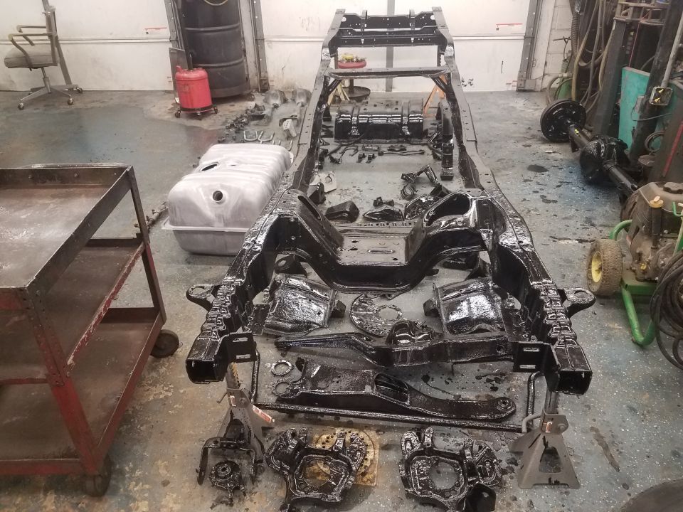 1994 Ford Bronco frame and parts in a garage