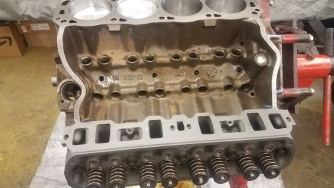 1994 Ford Bronco - A close-up view of a V8 engine block, likely from a Ford Bronco, is shown mounted on an engine stand. The engine block is partially disasse…