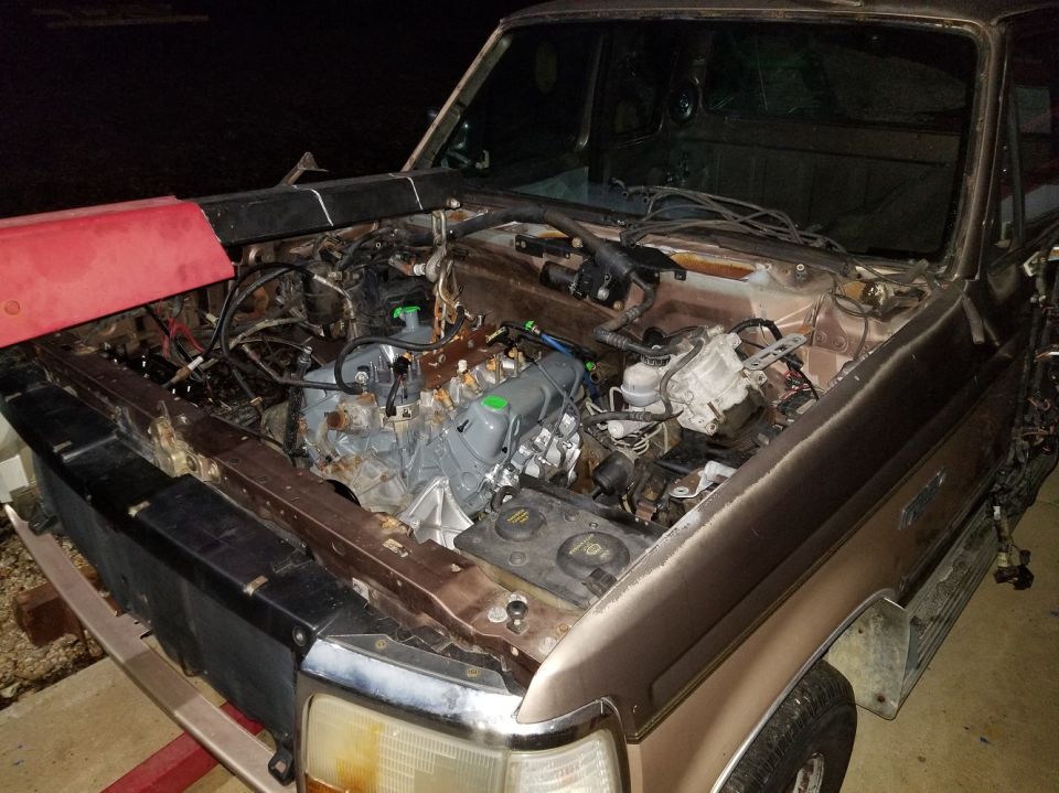 Ford F-150 engine bay, engine removed, showing frame and wiring. Appears to be a 1990 model