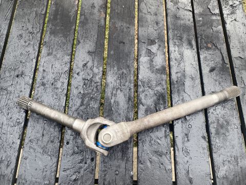 1994 Ford Bronco - A metal driveshaft with a universal joint is laid across a weathered, dark wooden surface. The driveshaft has splined ends on both sides an…