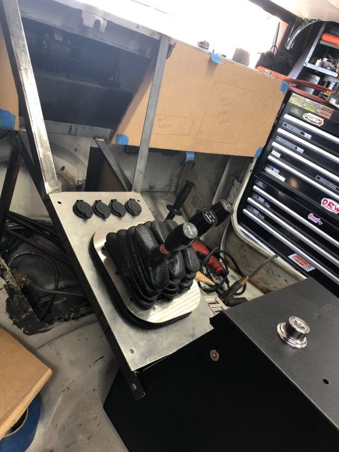 1992 Jeep Wrangler - A custom-built center console with a shifter boot and four power outlets is installed in a vehicle. A black toolbox is visible to the right…