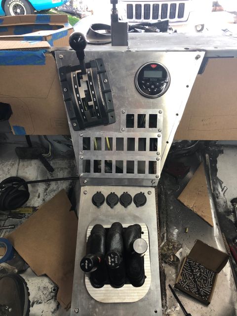 1992 Jeep Wrangler - A custom dashboard console is installed in a vehicle, featuring a gear shifter, a digital gauge, and multiple switch blanks. Four 12V power…