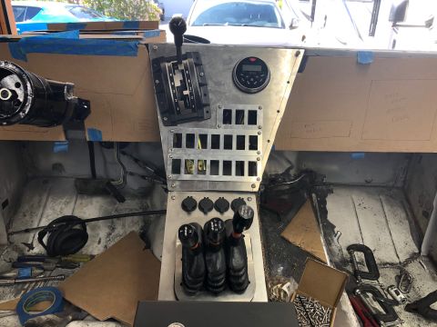 1992 Jeep Wrangler - The interior of a vehicle under construction shows a custom metal dashboard with a gear shifter, multiple toggle switches, and a digital ga…