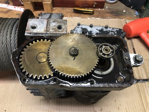 1980 Ford Bronco - A close-up view of the internal gears and a bearing of a winch mechanism, likely from a 1980 Ford Bronco. The gears are brass and appear to…