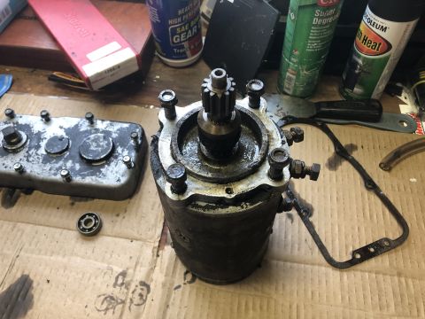 1980 Ford Bronco - A disassembled automotive starter motor and a transmission cover are on a workbench with various tools and lubricants. The starter motor is…