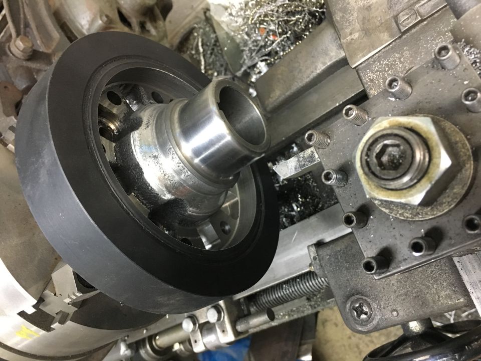 Close-up of a pulley being machined on a metal lathe.