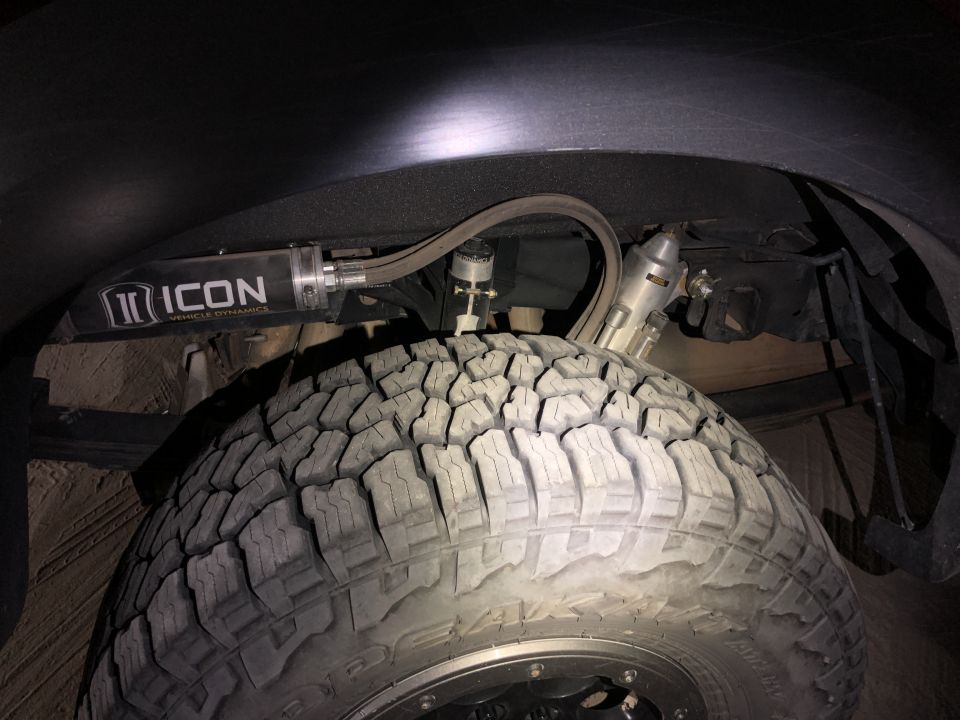 ICON Vehicle Dynamics shock absorber and off-road tire on a 2014 Ford F-150 rear suspension.