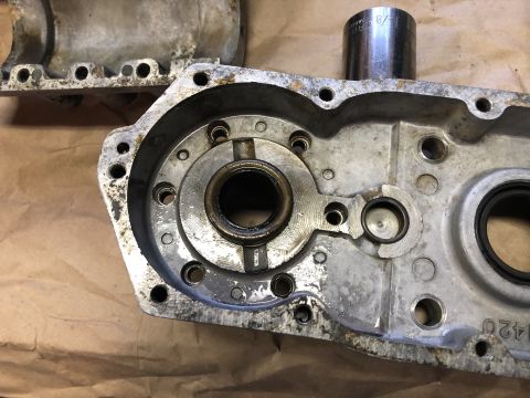 1980 Ford Bronco - A close-up view of the interior of a disassembled aluminum automotive transmission or differential housing. A silver socket wrench is resti…