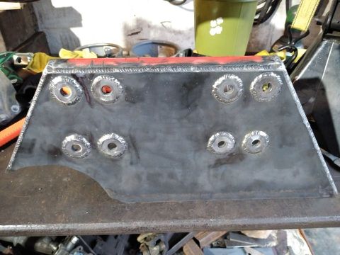 1985 Toyota Hilux - A fabricated metal component, likely a bracket or reinforcement plate, displays numerous welded bolt holes.