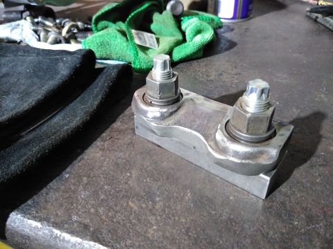 1985 Toyota Hilux - A metal bracket with bolts and nuts is shown on a workbench, with tools and cloths in the background.