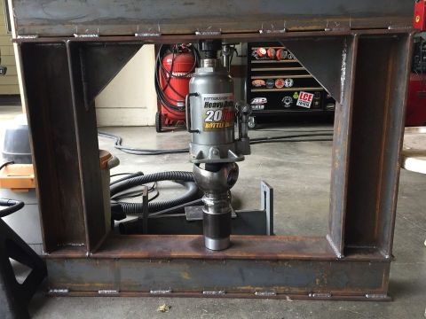 1985 Toyota Hilux - Hydraulic press frame holding a 20-ton bottle jack, with an air compressor and tool chest in the background.