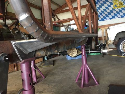 1985 Toyota Hilux - The vehicle's frame and suspension are being worked on in a garage setting.