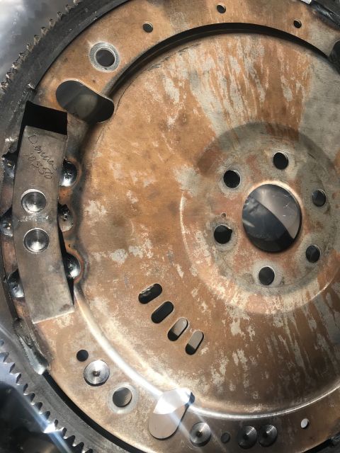 2000 Ford Explorer - A close-up view of a rusty flywheel, showing stamped text and a website watermark.