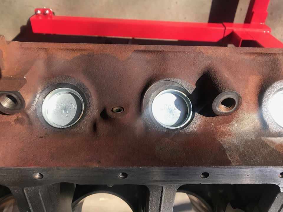 Engine block with freeze plugs, one showing "SFC 50 12"