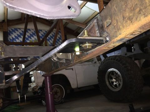 1985 Toyota Hilux - Custom bracket installation on a vehicle frame, with another vehicle in the garage.