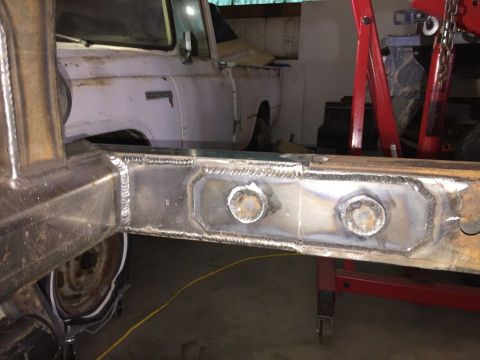 1985 Toyota Hilux - Close-up of a newly welded truck frame section, with another vehicle visible in the background.