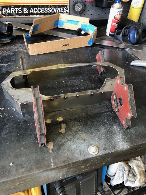 1992 Jeep Wrangler - A metal frame part is shown on a workbench, with a cardboard template and tools nearby.
