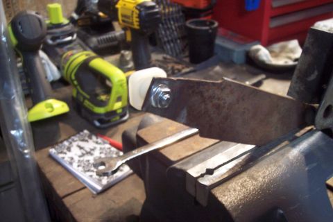1995 Ford Bronco - Tools and a metal part are set up on a workbench for some kind of repair or fabrication.