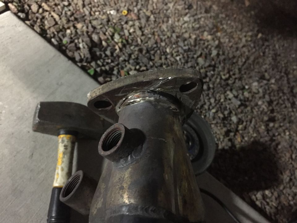 Exhaust pipe flange with threaded fittings and visible welds