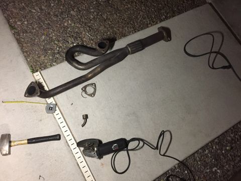 1993 Mercury Tracer - Tools and exhaust parts laid out on a concrete surface, possibly for repair or modification.