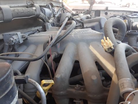 1994 Ford Bronco - Engine bay of a 1994 Ford Bronco, showing the intake manifold and various hoses and components.
