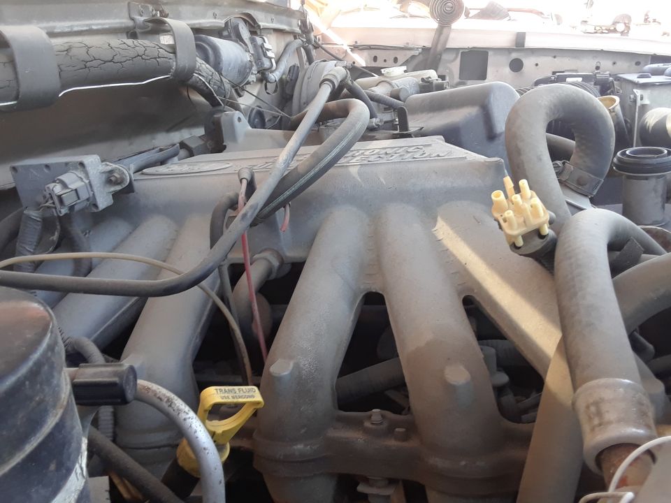 1994 Ford Bronco engine bay with intake manifold and hoses visible