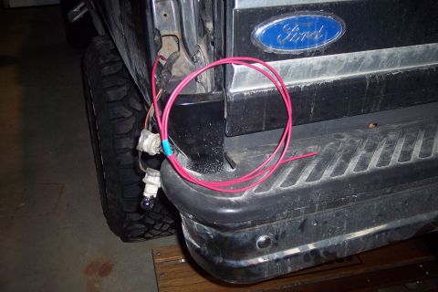 1995 Ford Bronco - Wiring is exposed near the rear bumper and taillight assembly of a Ford Bronco.