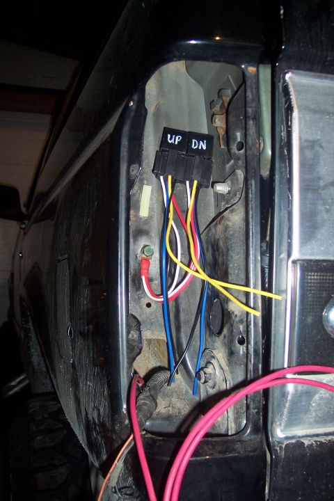 1995 Ford Bronco - Close-up of a wiring harness with "UP DN" labels, likely for a power window or seat, attached to the interior of a vehicle.