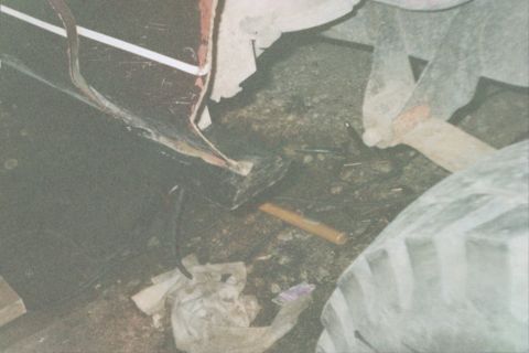 1979 Ford Bronco - A close-up view of a vehicle's tire and undercarriage, with various items scattered on the ground.