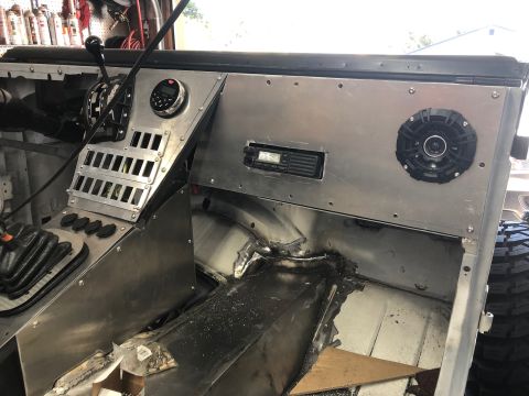 1992 Jeep Wrangler - The interior of a vehicle shows a custom aluminum dashboard with a shifter, radio, and speaker installed.