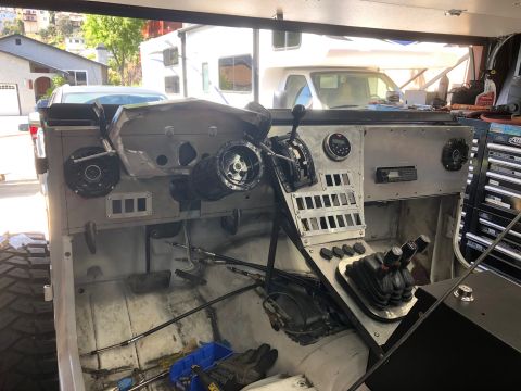1992 Jeep Wrangler - The interior of a vehicle shows a custom dashboard with various controls and a large tire.