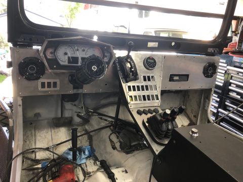1992 Jeep Wrangler - The interior of a vehicle features a custom dashboard with aftermarket gauges, switches, and a modified center console.