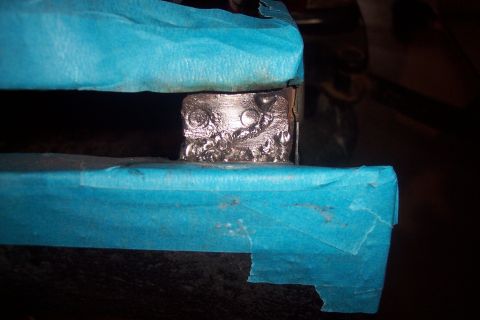 1995 Ford Bronco - A close-up view shows a metal patch weld, secured with blue masking tape, indicating repair work.