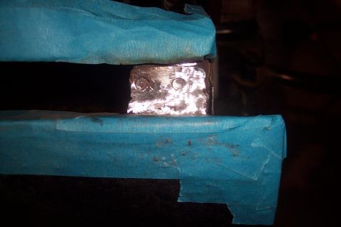 1995 Ford Bronco - A close-up view shows a metal bracket that has been welded and is partially covered with blue tape.