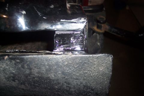 1995 Ford Bronco - Detail of a patch weld on a vehicle's frame, showing metal repair work.