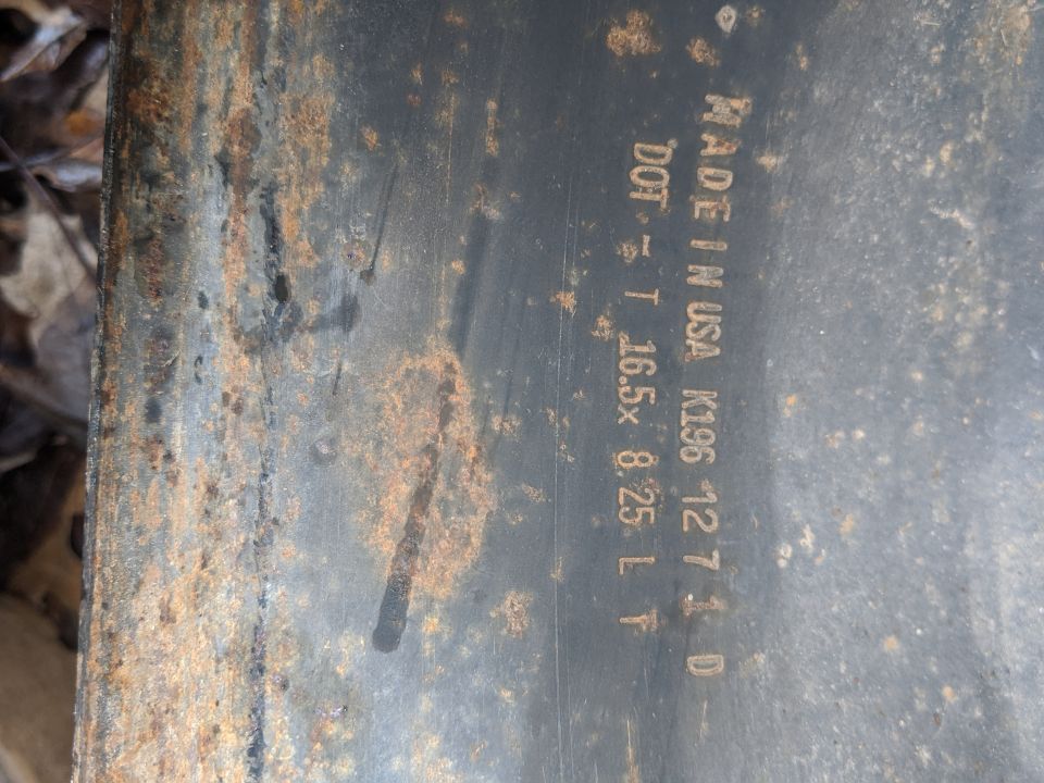 Rusted metal part with text "MADE IN USA K196 12 7 1 D DOT T 16.5x 8.25 L F" and "SUPERMOTORS www.supermotors.net"