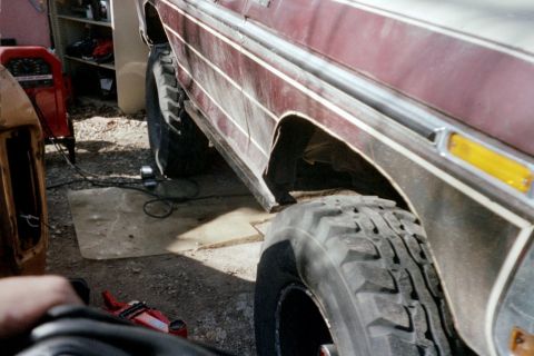1979 Ford Bronco - Close-up of a maroon SUV's side, showing its lifted suspension and large off-road tires.