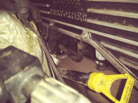 1996 Ford Bronco - A close-up view of engine components, including a yellow transmission fluid dipstick and part of a silver "PERFORMER" branded engine cover.…