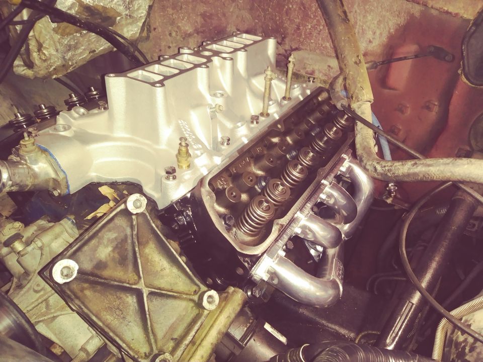V8 engine with silver intake manifold and chrome exhaust headers