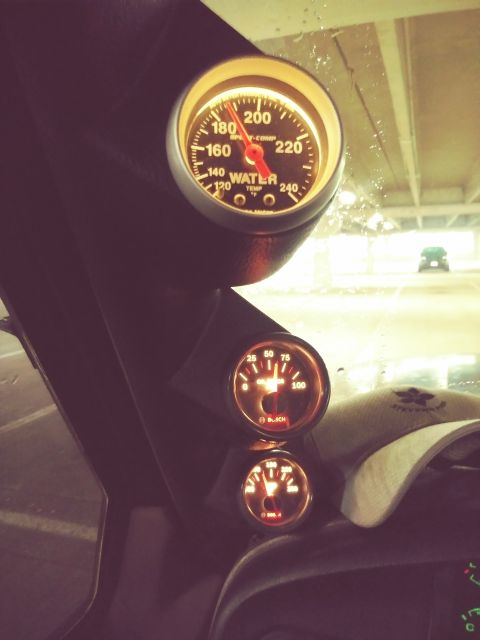 1996 Ford Bronco - A close-up interior shot shows three illuminated gauges mounted on a dark pillar. The top gauge is a water temperature gauge, while the bot…