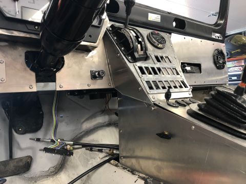 1992 Jeep Wrangler - The interior of a vehicle's dashboard area shows a custom metal console with a gear shifter, various switches, and wiring. A steering colum…