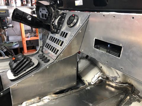 1992 Jeep Wrangler - The interior of a custom-built vehicle features a brushed aluminum dashboard with a steering column, shifter, and a radio mounted in a cuto…